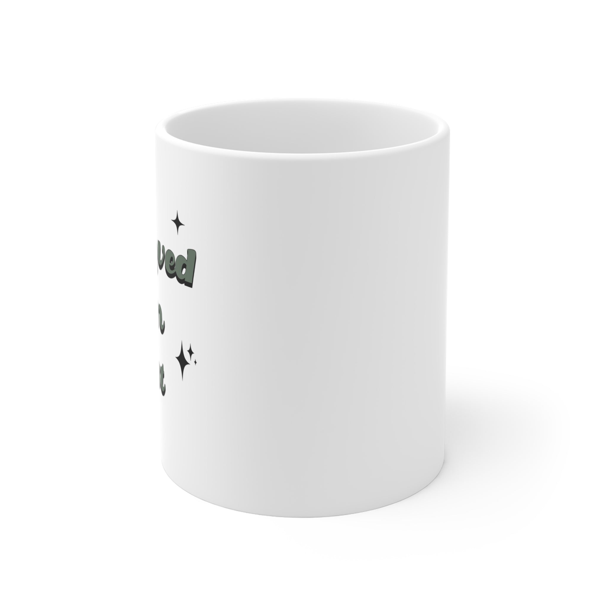 She Loved Him First Mug — white ceramic with deep green script and sparkle accents — ThrivingMoms
