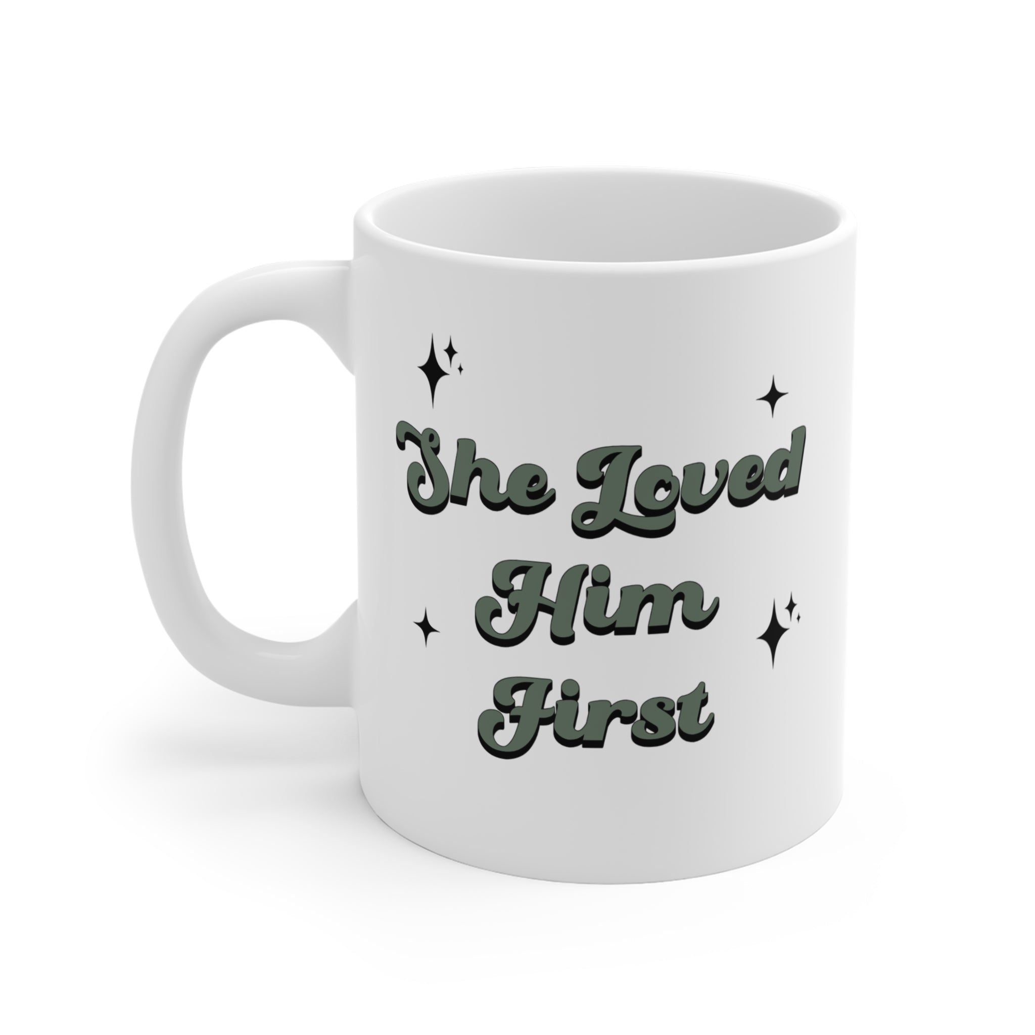 She Loved Him First Mug — white ceramic with deep green script and sparkle accents — ThrivingMoms